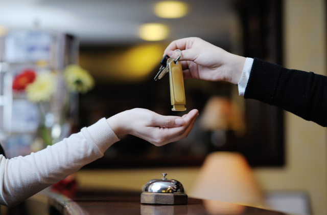 frontdesk clerk handing keys to customer - featured image